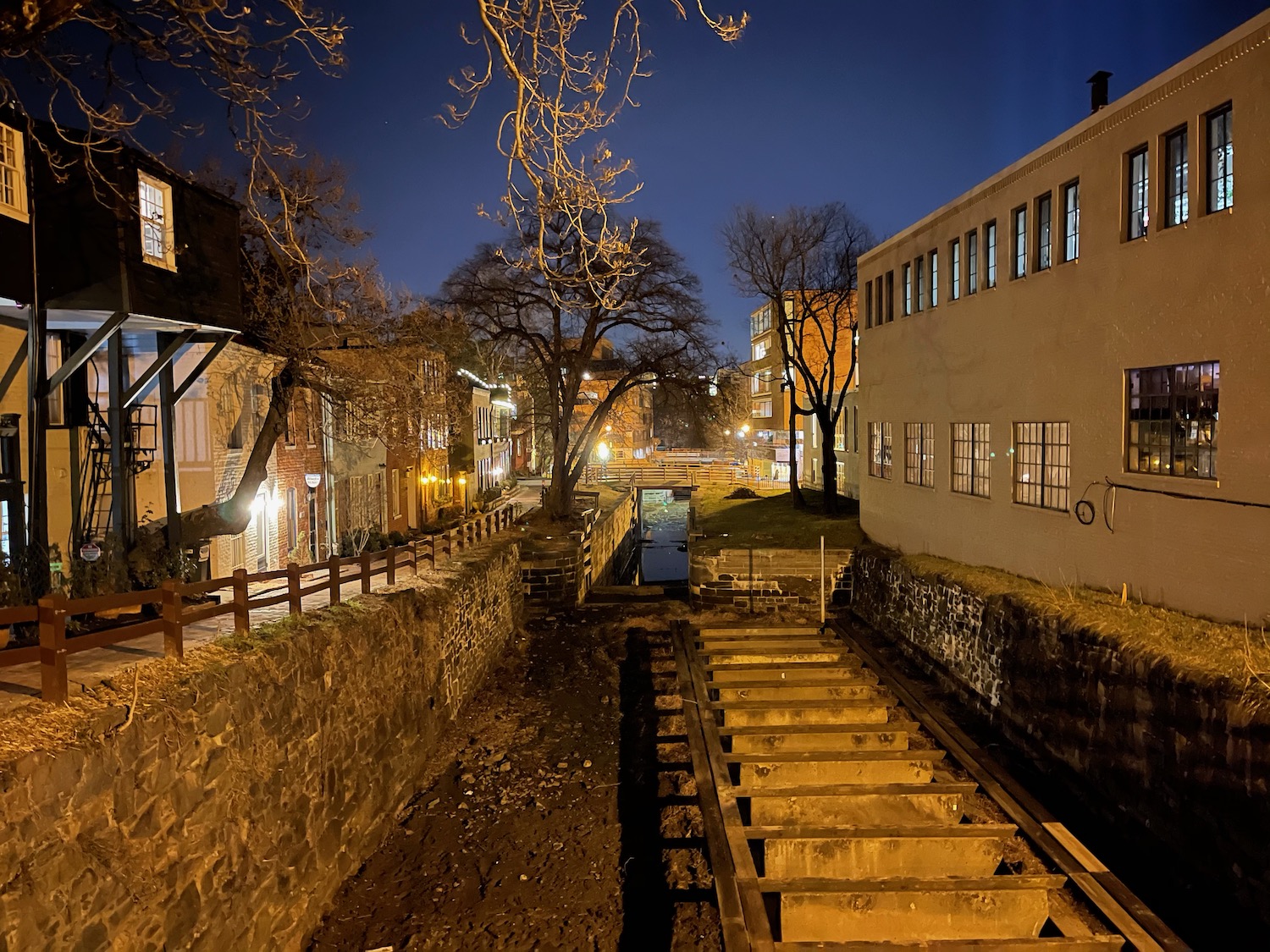 a small canal between buildings at night