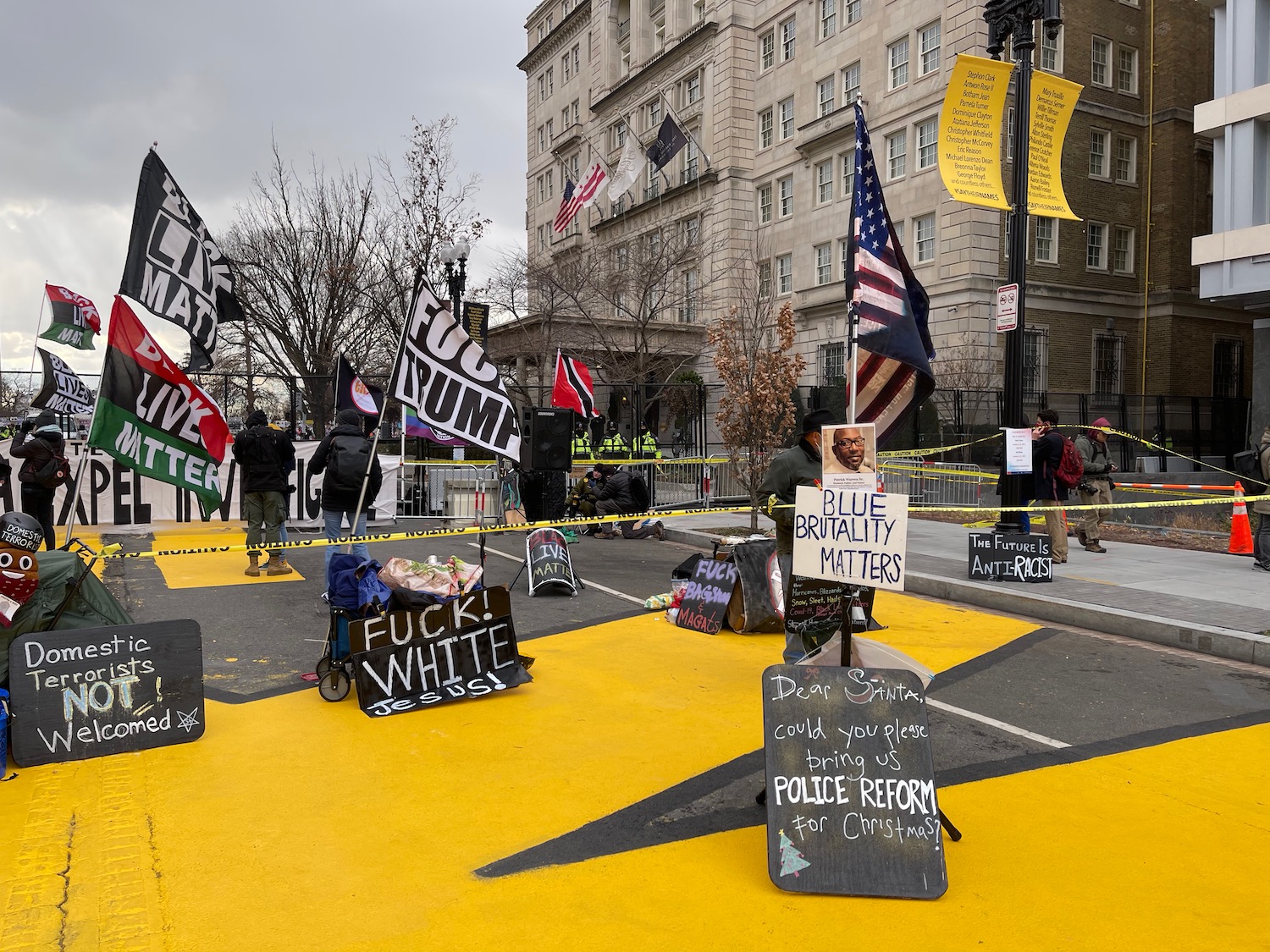 a group of people standing on a street with signs and flags