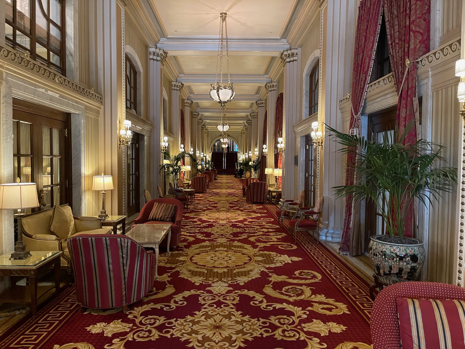 a long hallway with red carpet and chairs