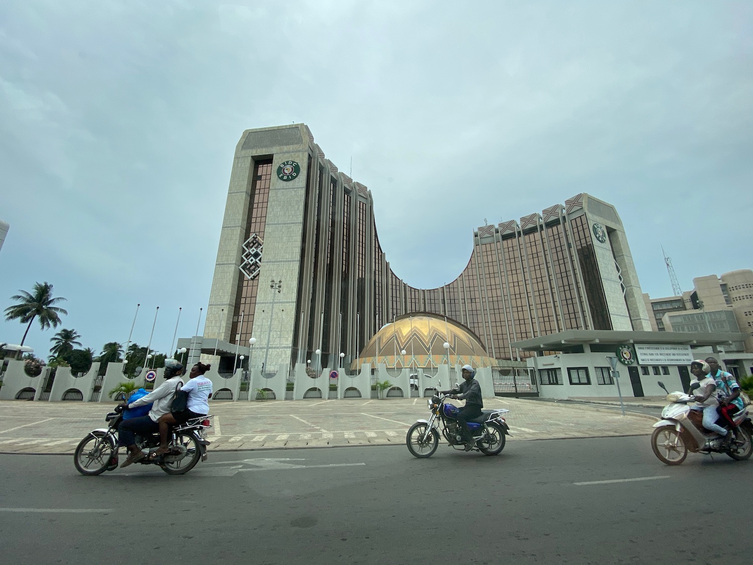 a group of people riding motorcycles in front of a large building