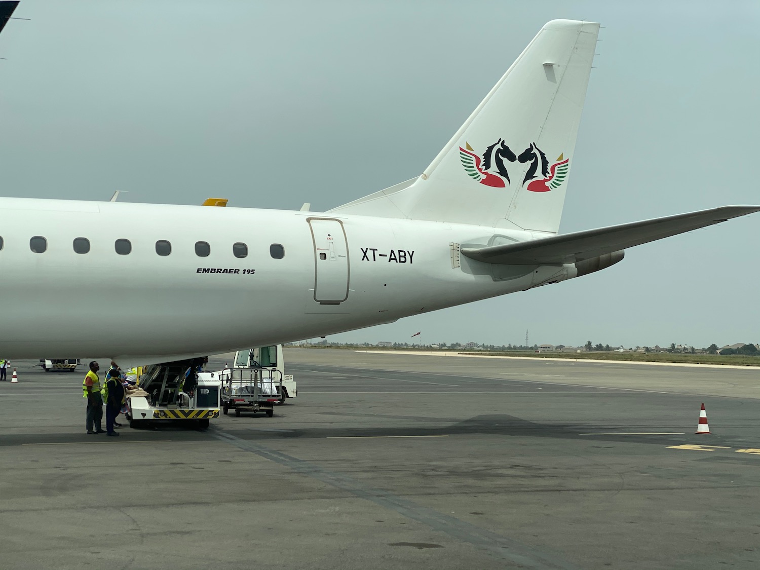 a white airplane with people standing next to it