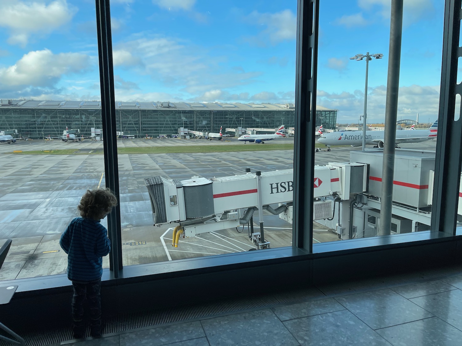 a child looking out a window at an airport