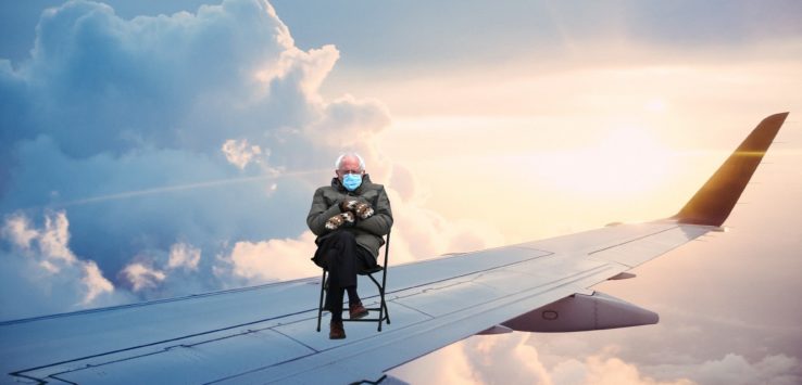 an old man sitting in a chair on an airplane wing