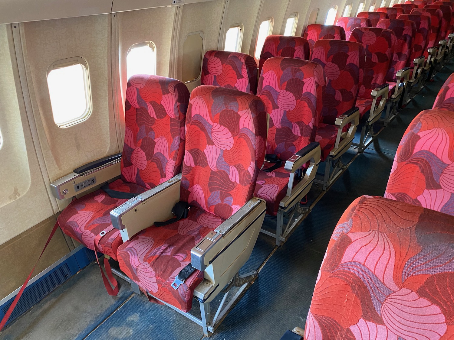 a row of red seats on an airplane