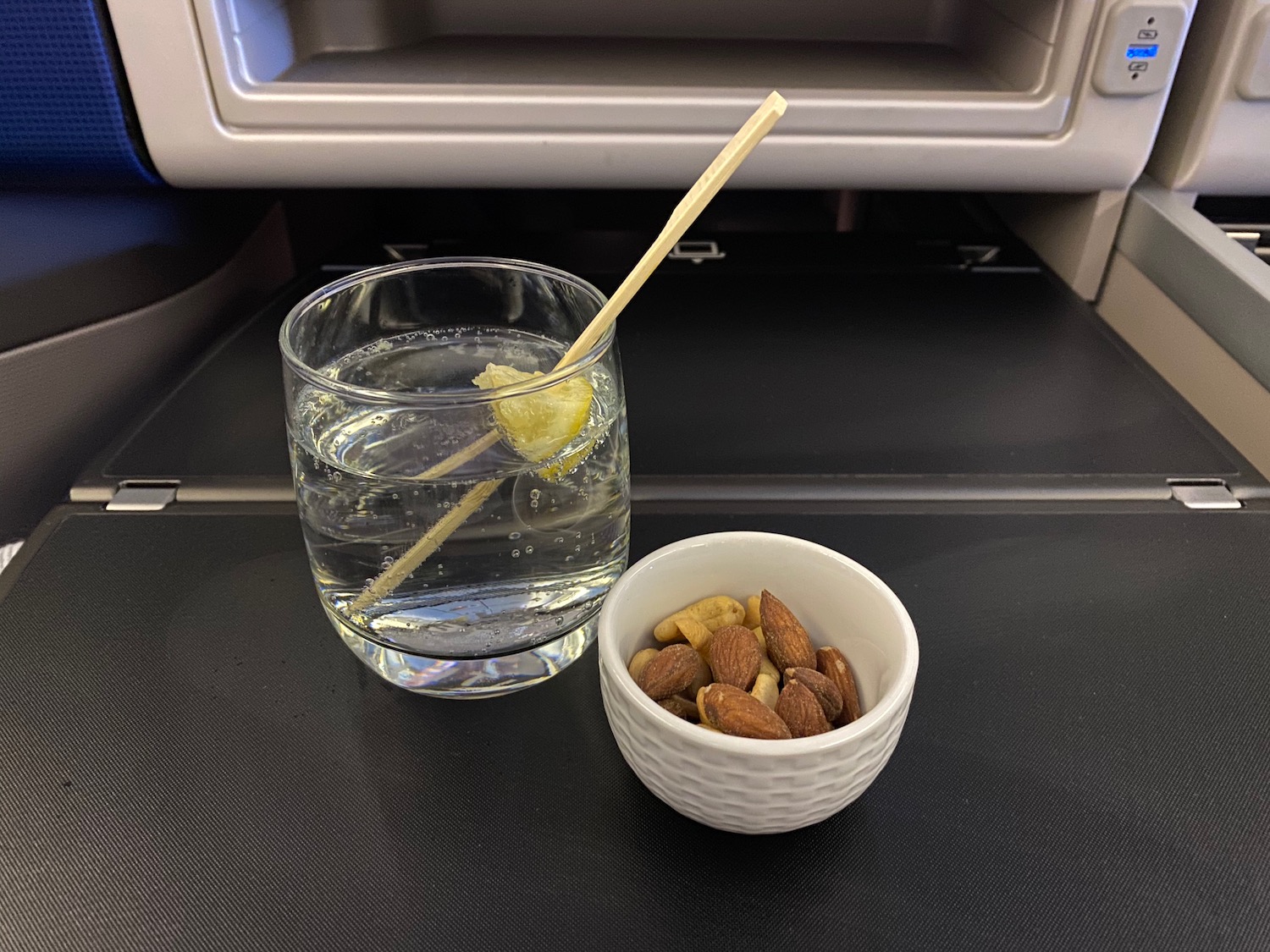 a glass of water and a bowl of nuts