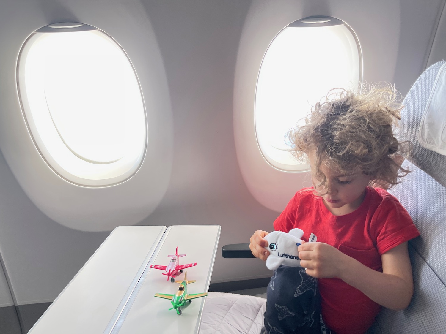 a child sitting in an airplane with toy planes