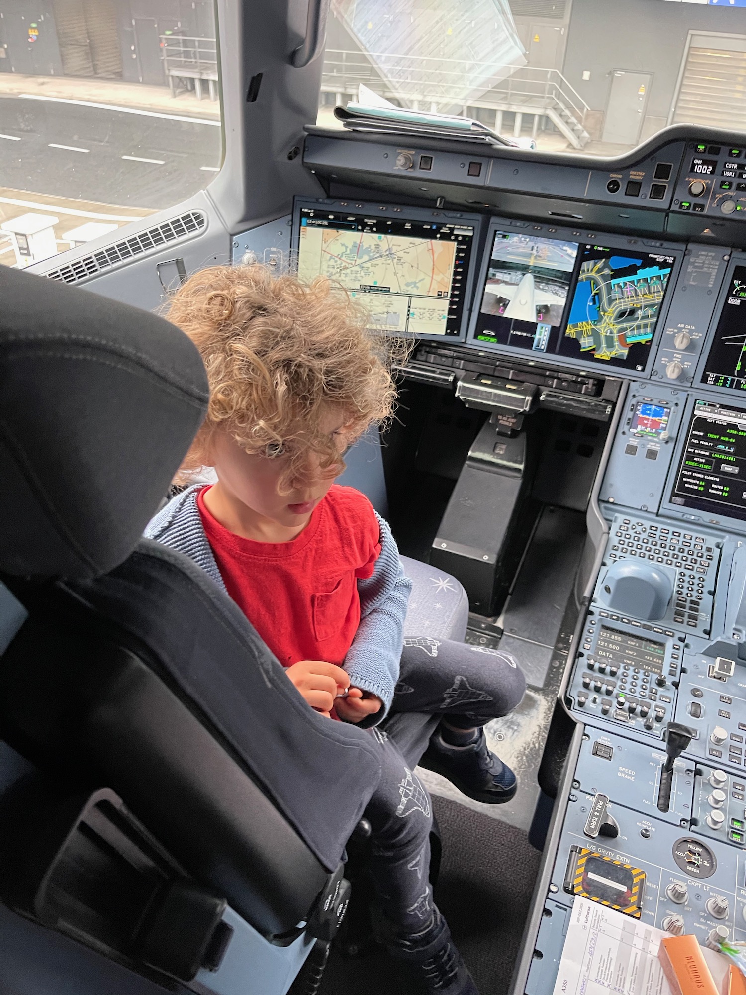 a child sitting in a cockpit of an airplane