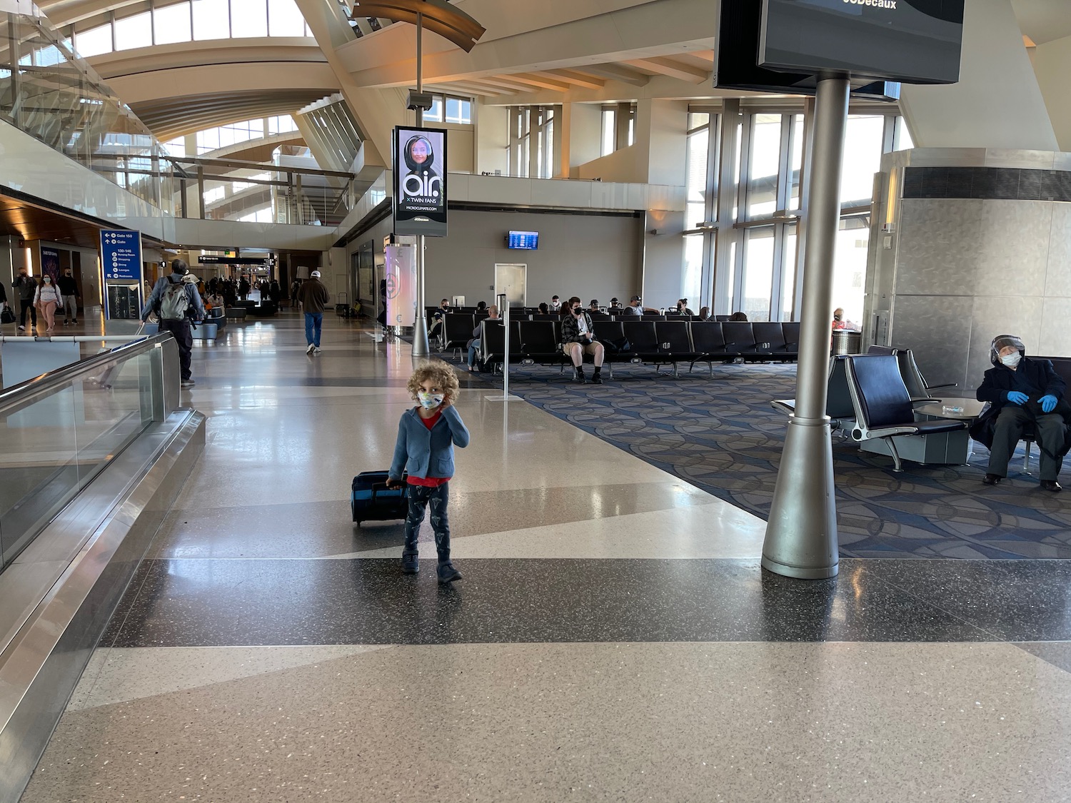 a child with a face mask in an airport