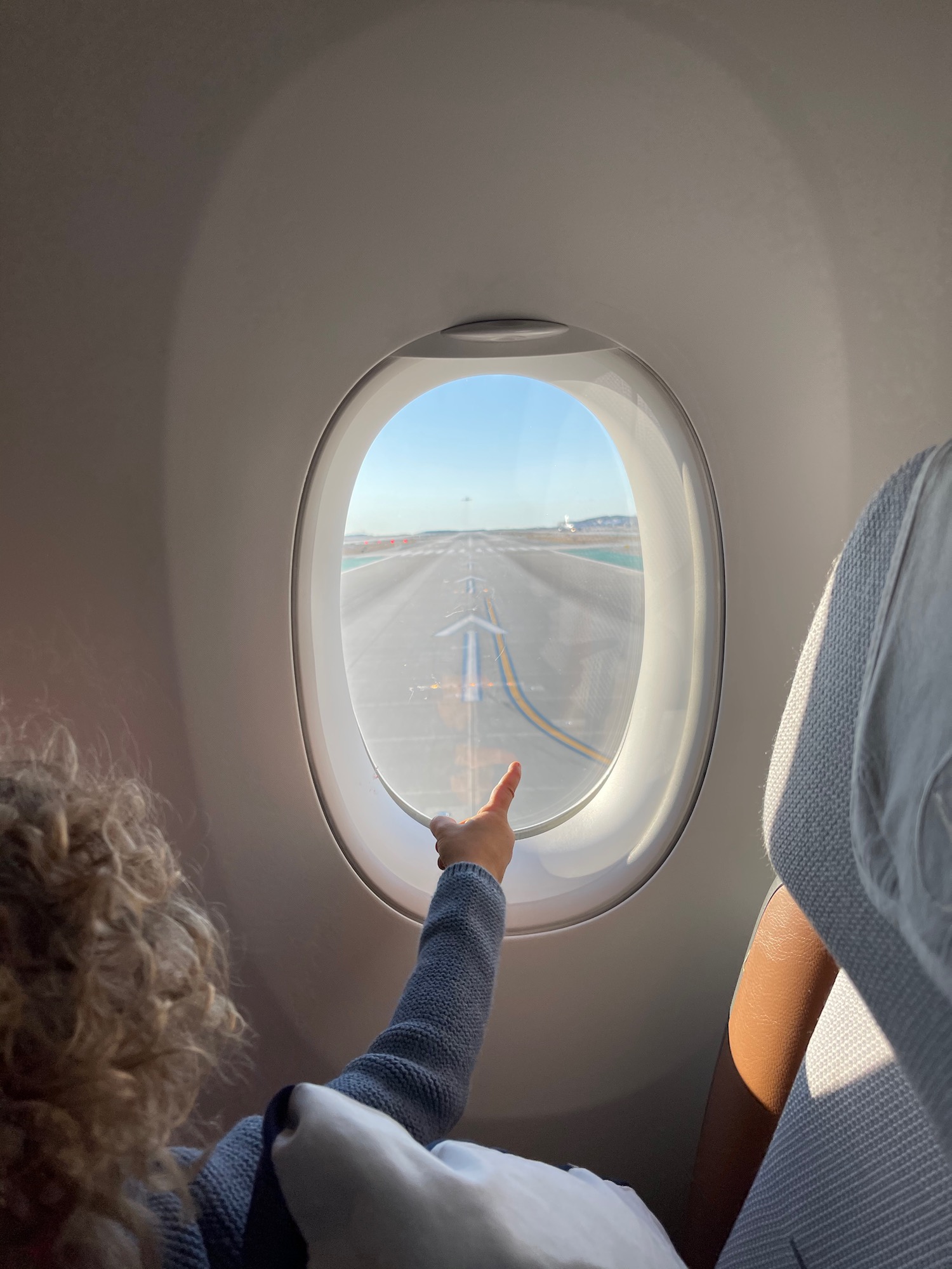 a person pointing at an airplane window