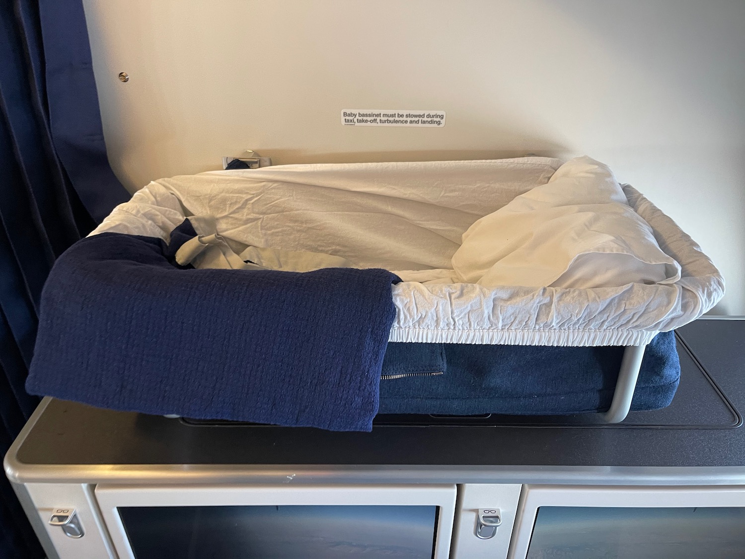 a baby crib with a blanket on top of a cabinet