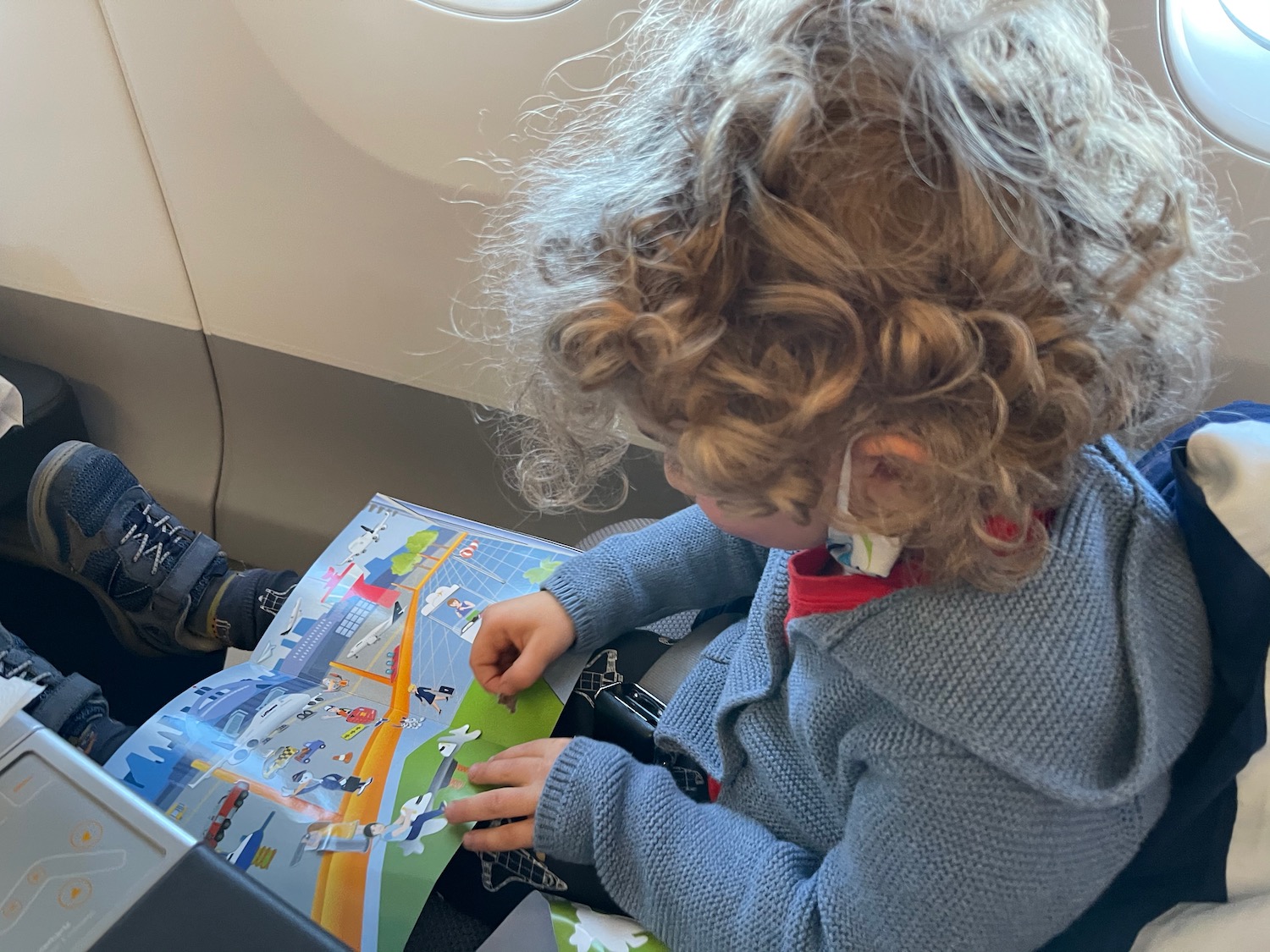 a child reading a book on an airplane