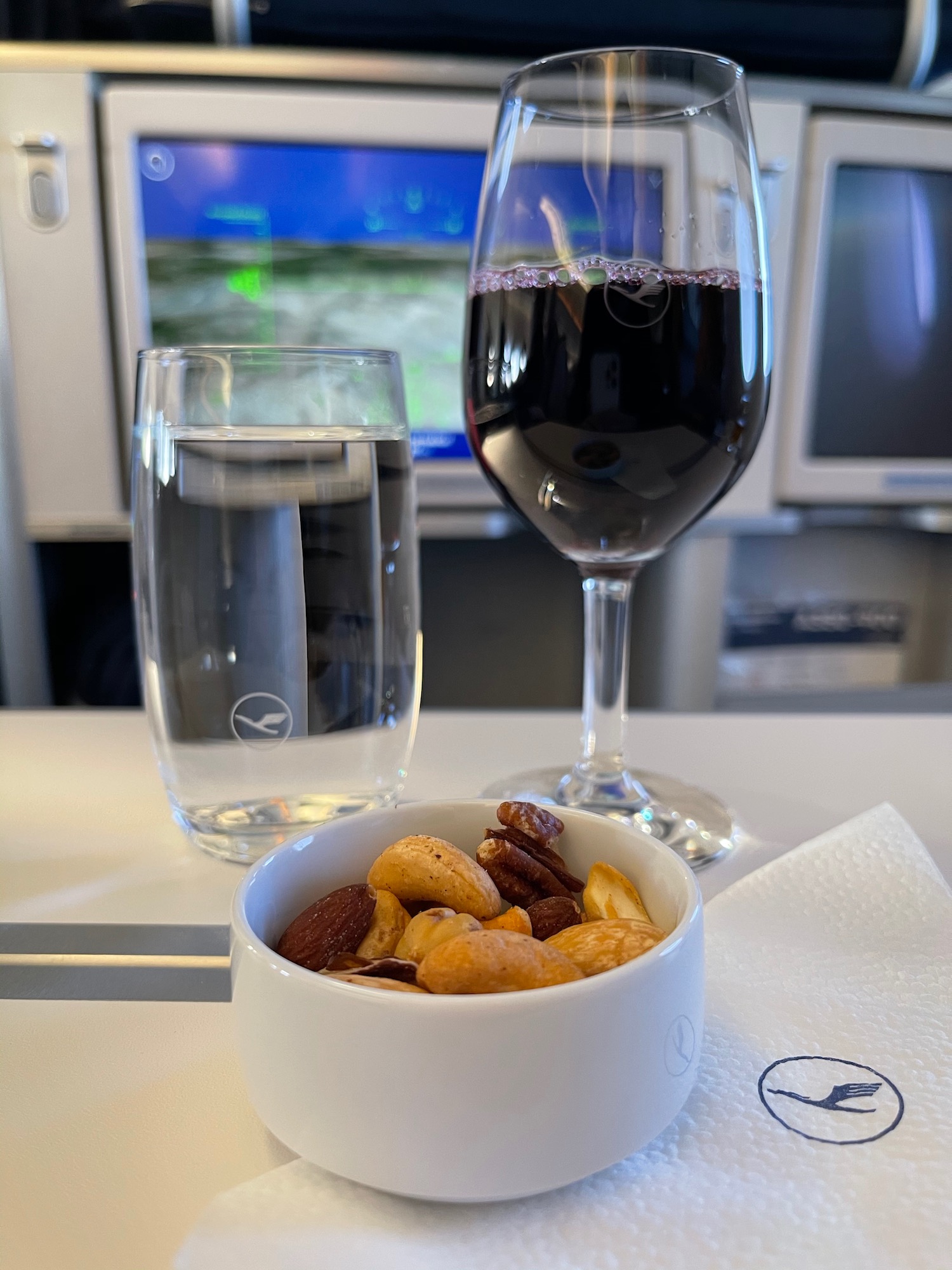 a bowl of nuts and a glass of wine