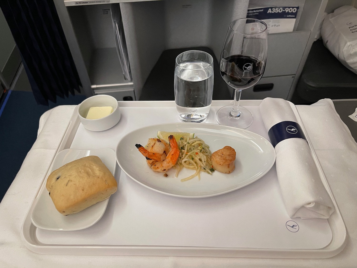 a plate of food and a glass of wine on a tray