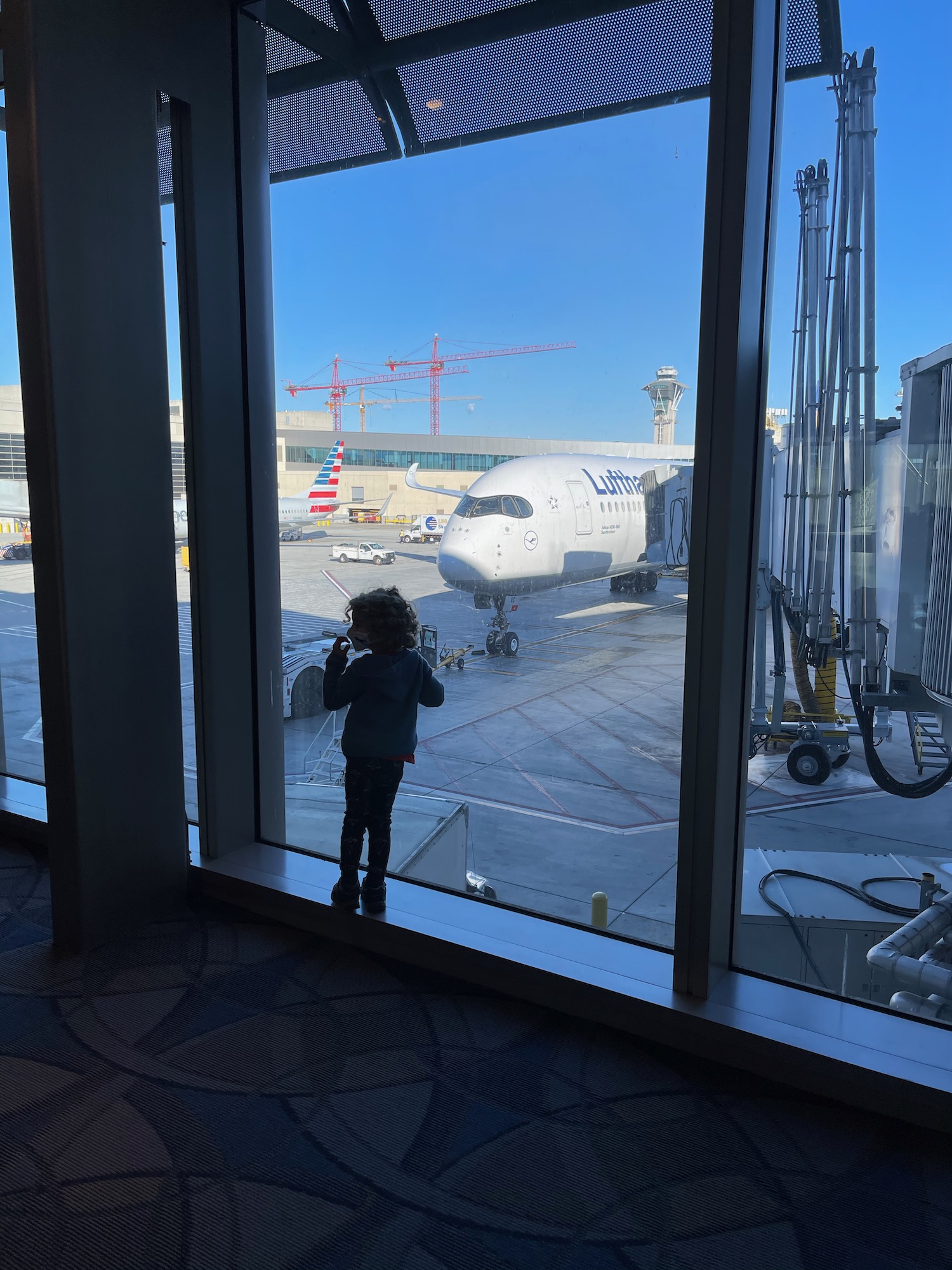 a child standing in front of a large window