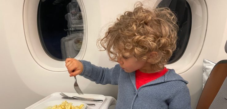 a child eating food on an airplane