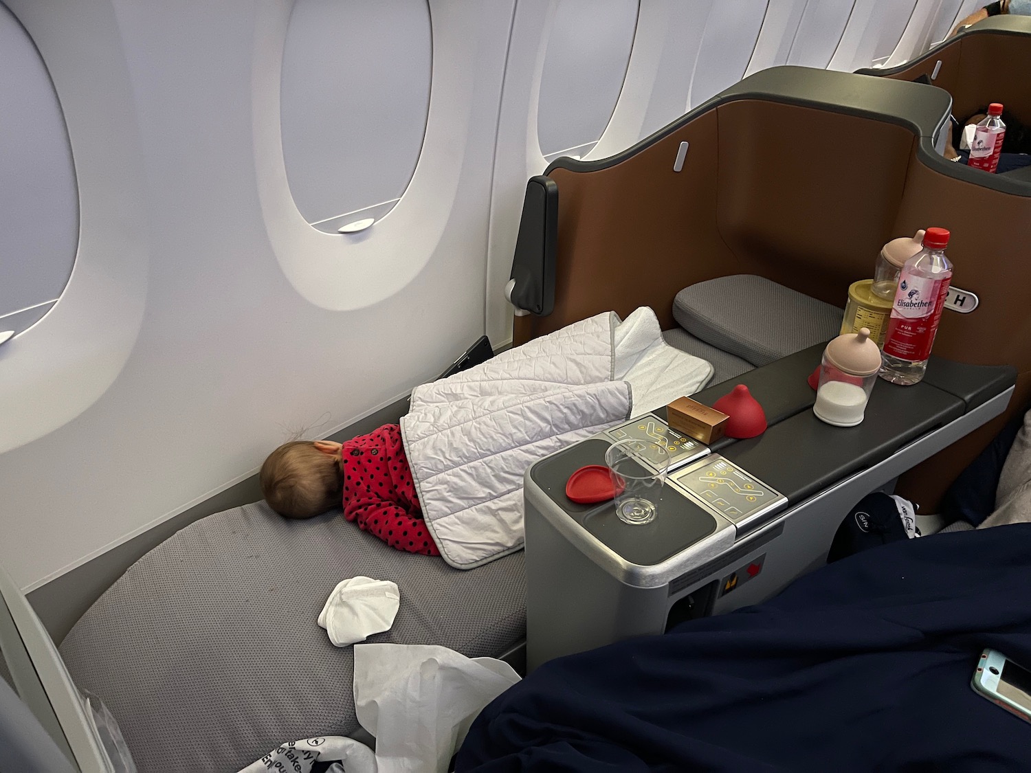 a child sleeping on a bed in an airplane