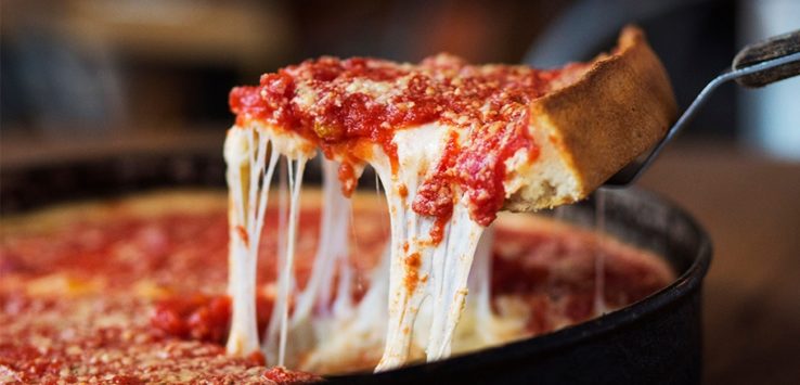 a slice of pizza being dipped in cheese