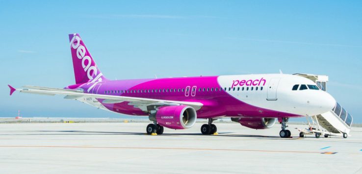 a pink and white airplane on a runway