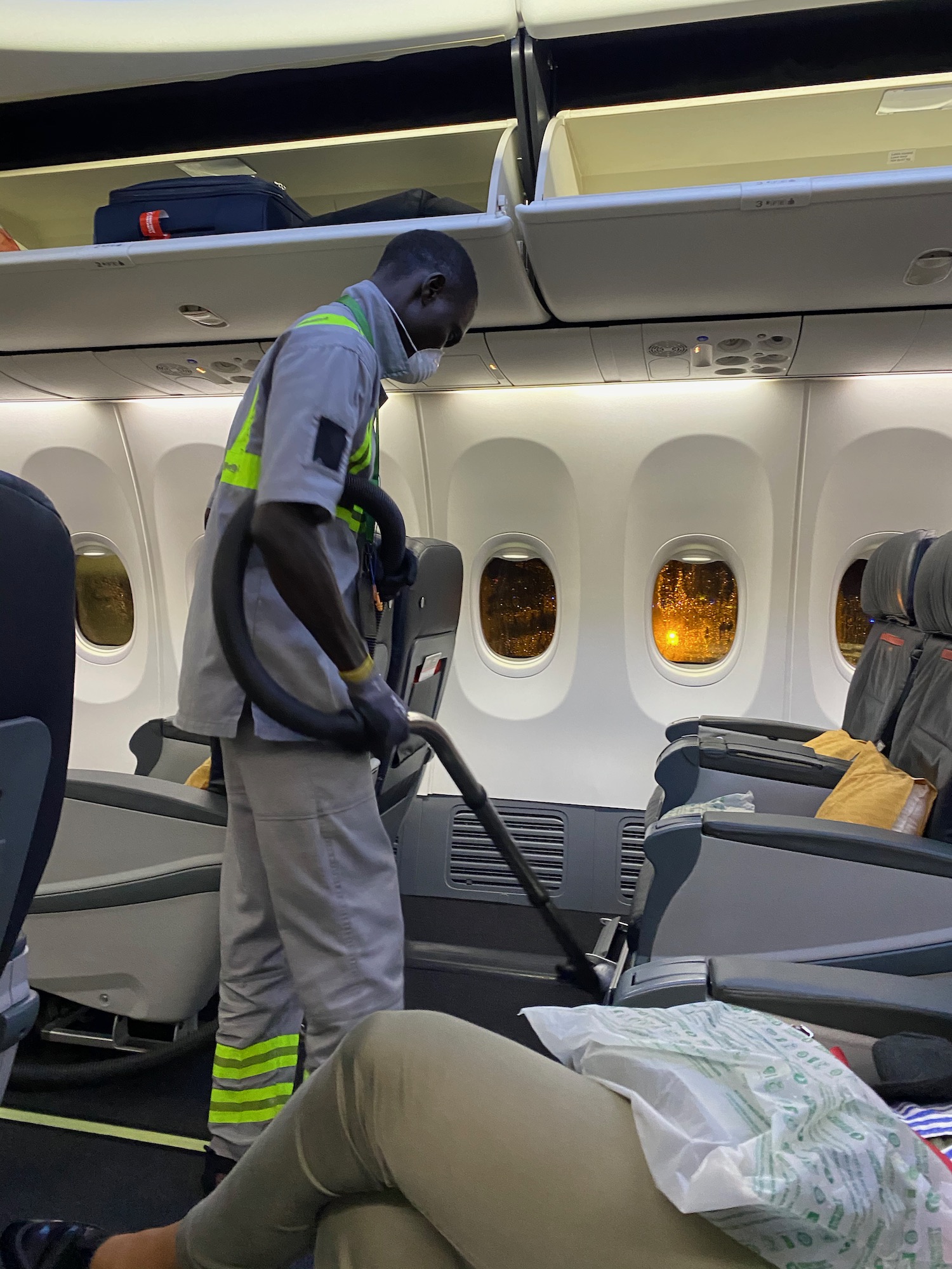 a man vacuuming the seats of an airplane