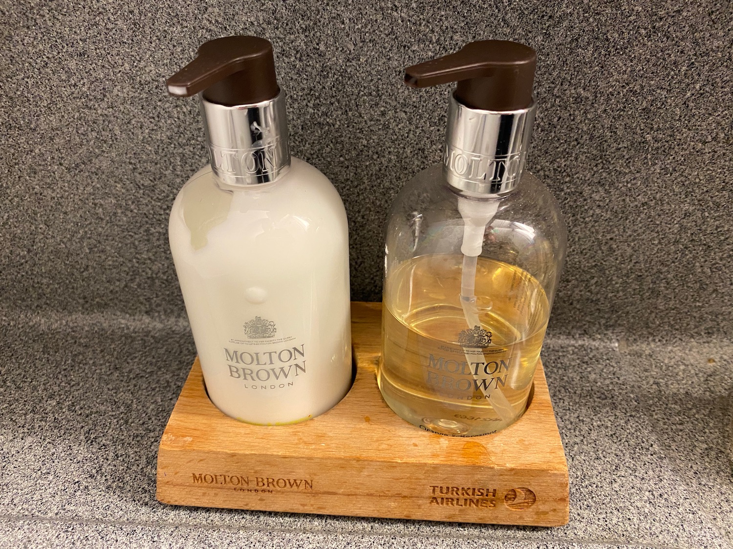 a couple of soap dispensers on a wood stand