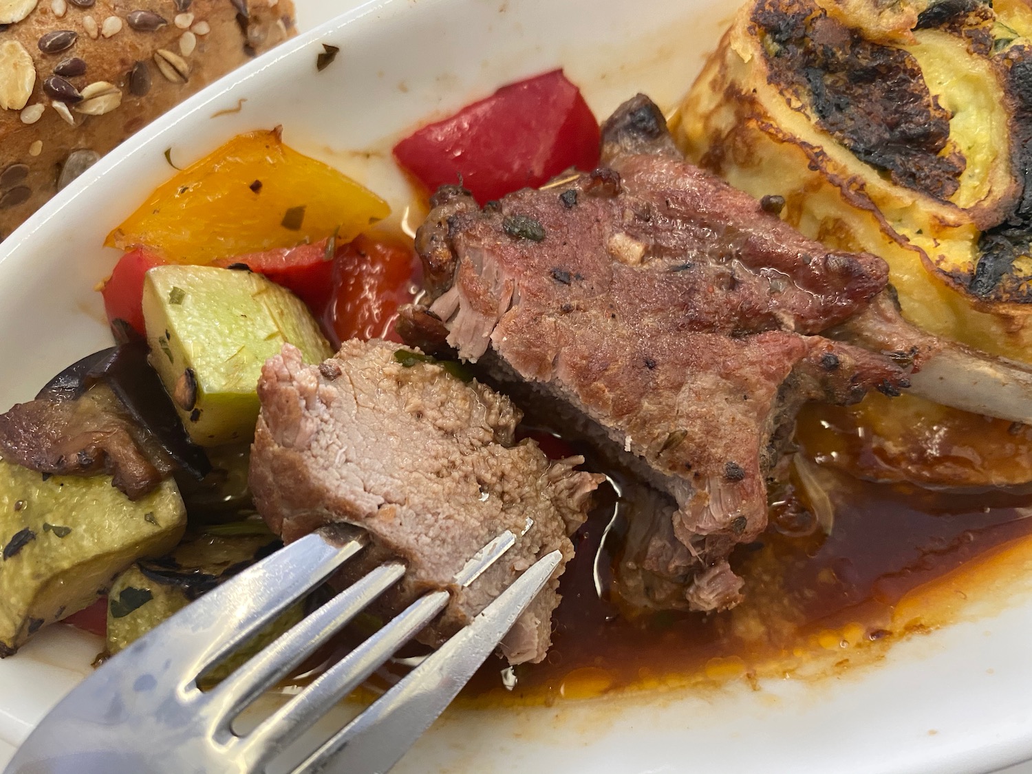 a fork on a plate of meat and vegetables