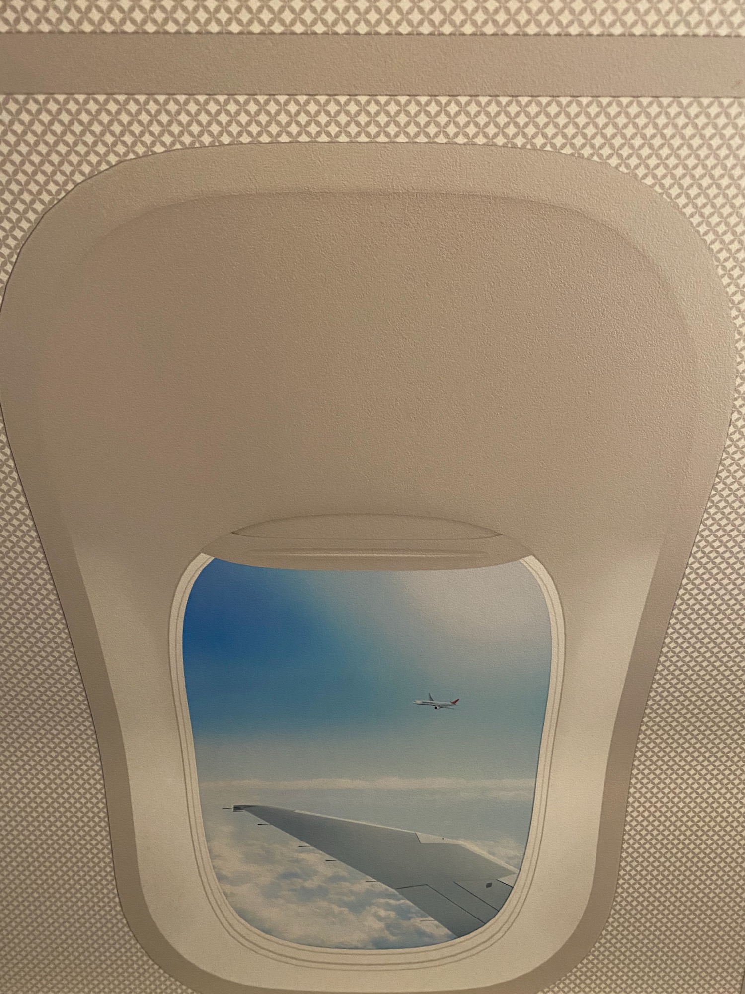 an airplane window with a wing and blue sky