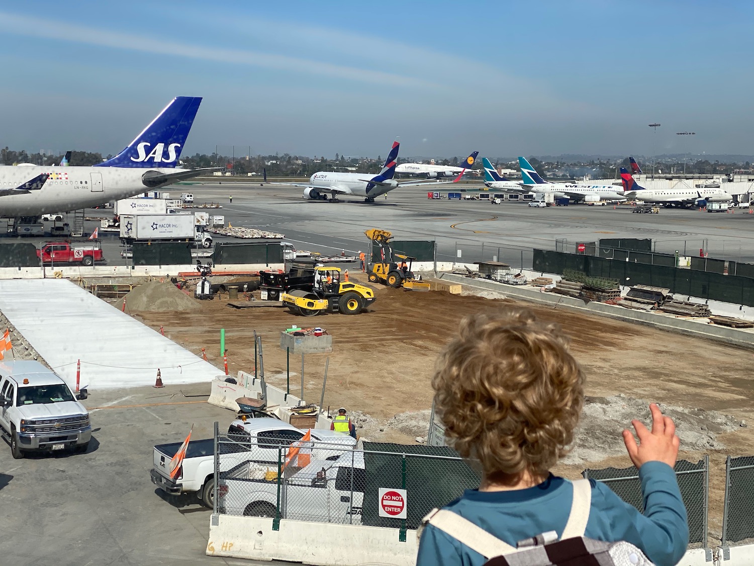 a child looking at airplanes at an airport