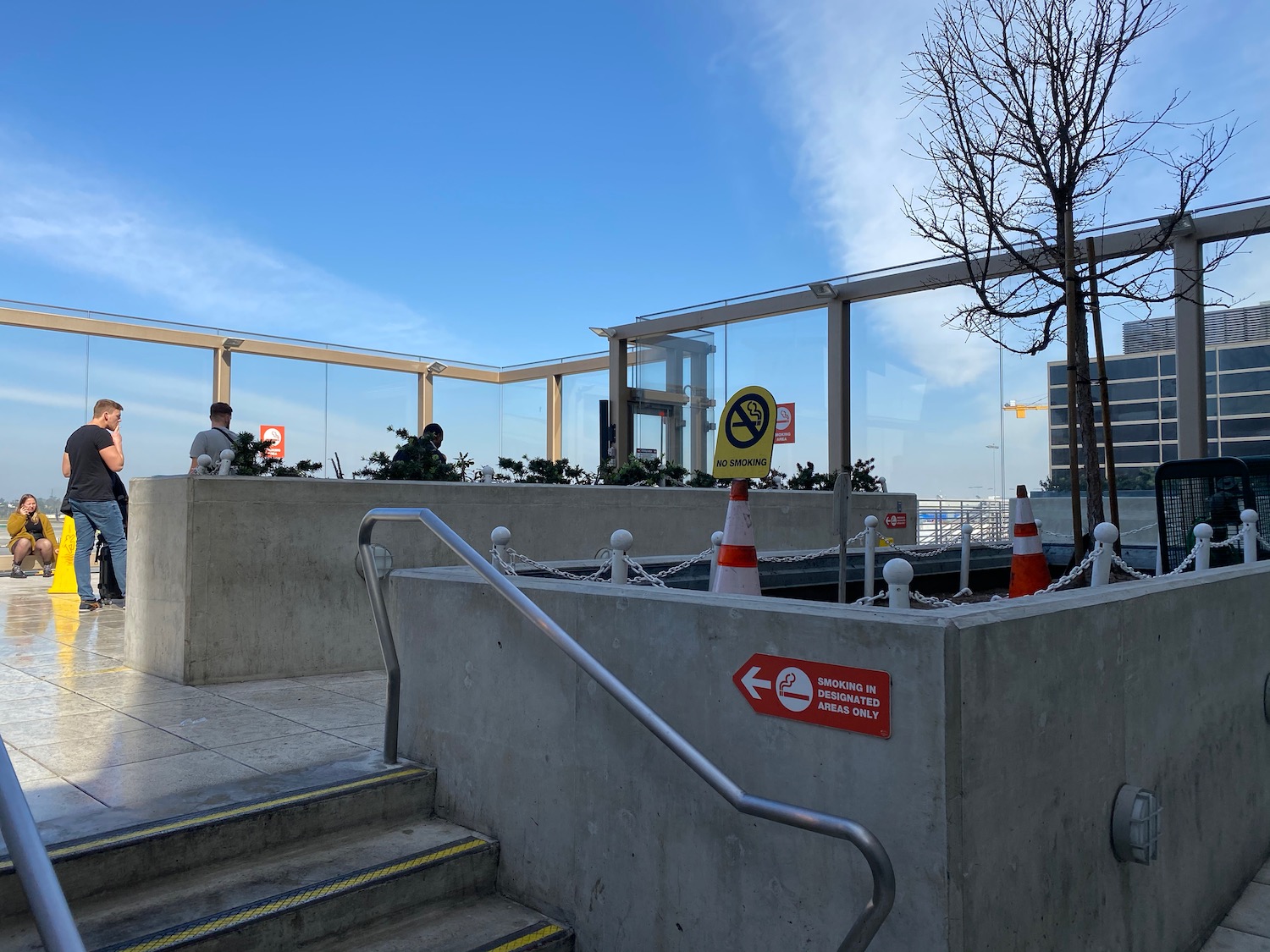 a concrete wall with orange and white cones and a railing