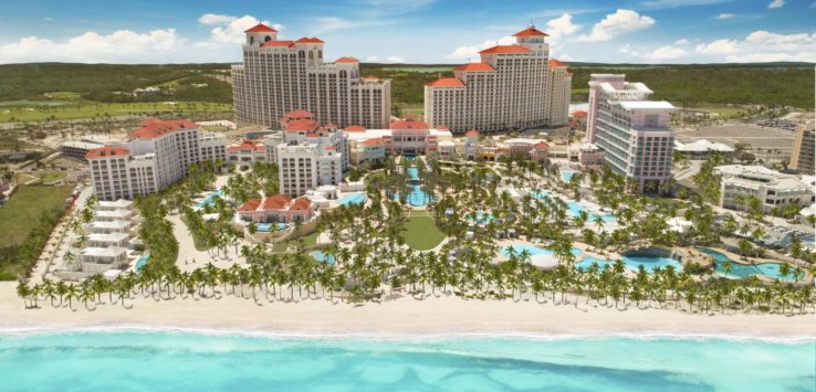 a beach with many buildings and palm trees