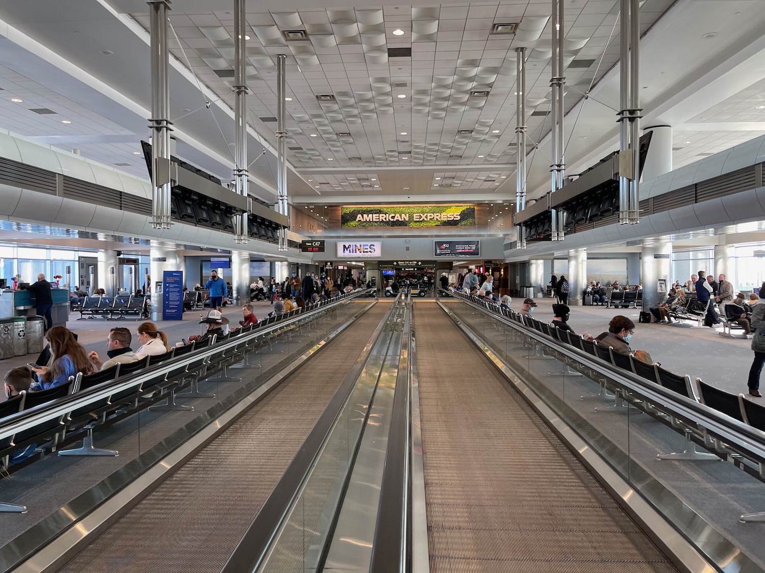 a group of people sitting on a conveyor belt in an airport