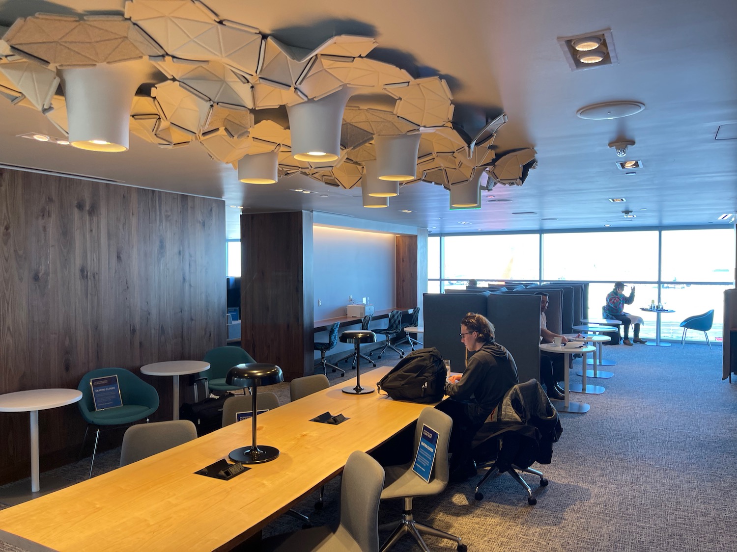 a person sitting at a table in a room with chairs and tables