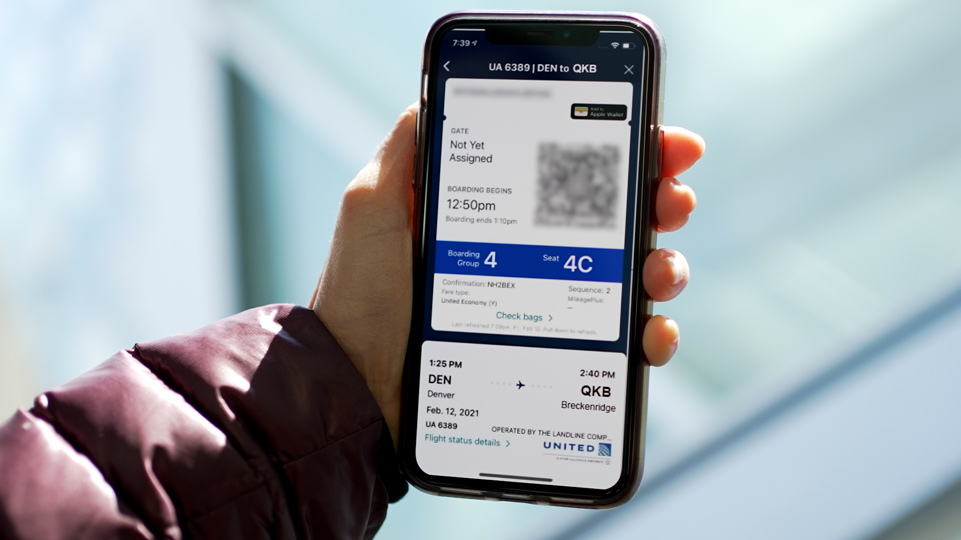 a hand holding a phone with a flight ticket on screen