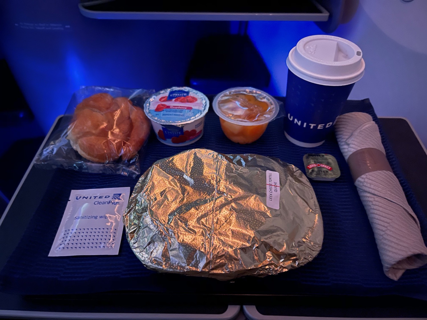 food on a tray with a drink and a bagel