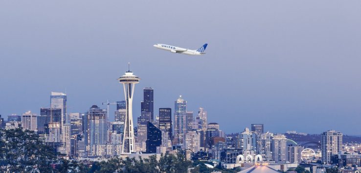 a plane flying over Space Needle