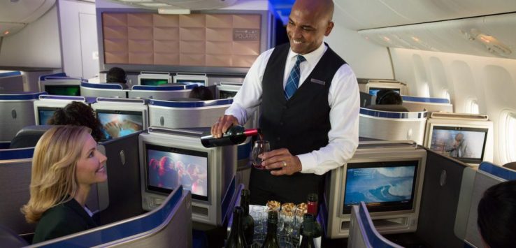 a man serving a woman in an airplane