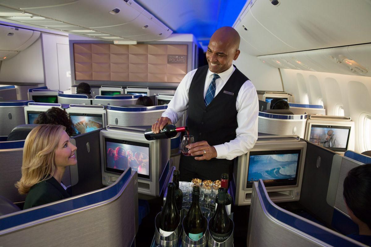 a man serving a woman in an airplane