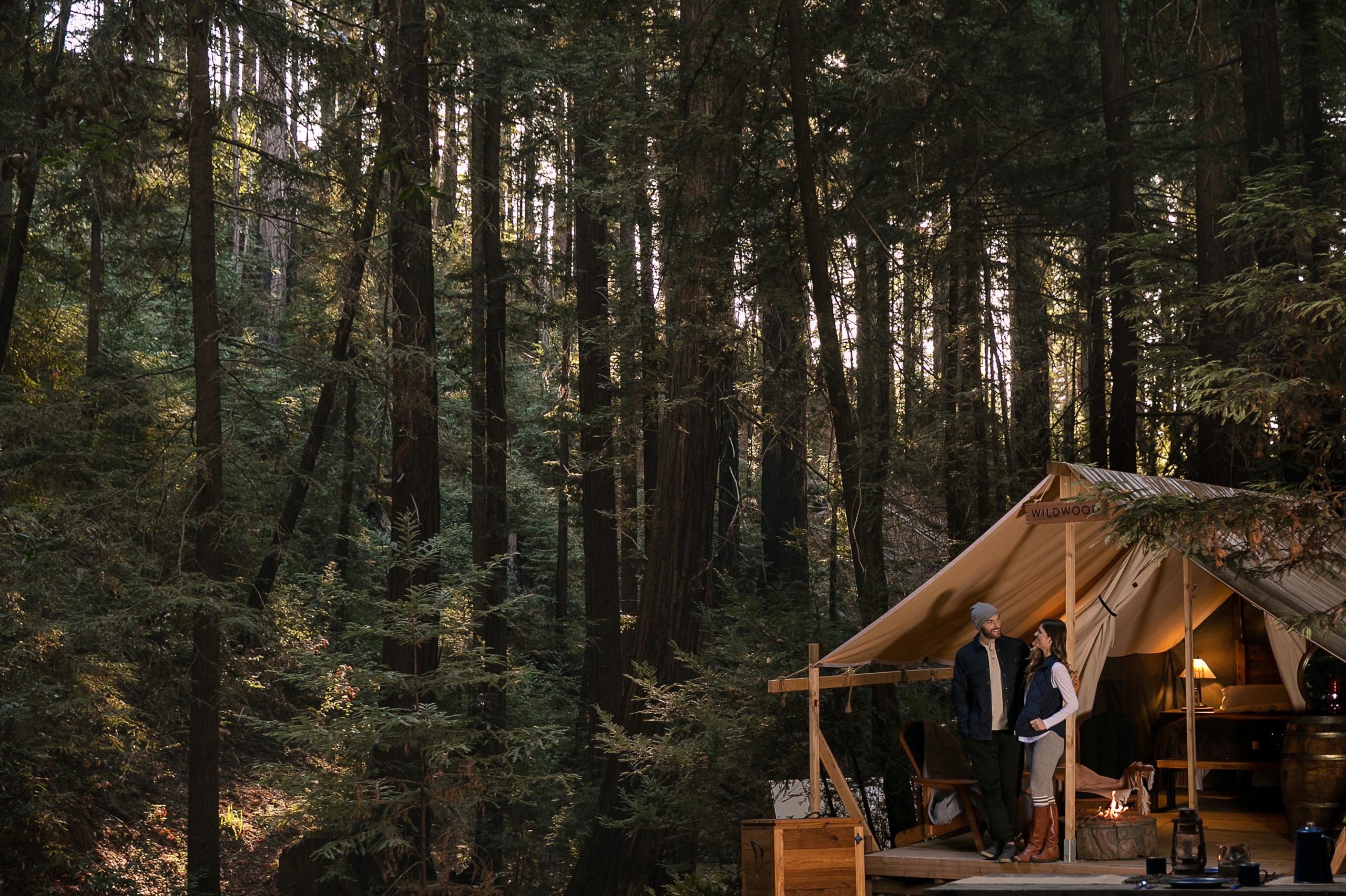 a couple standing on a porch in the woods