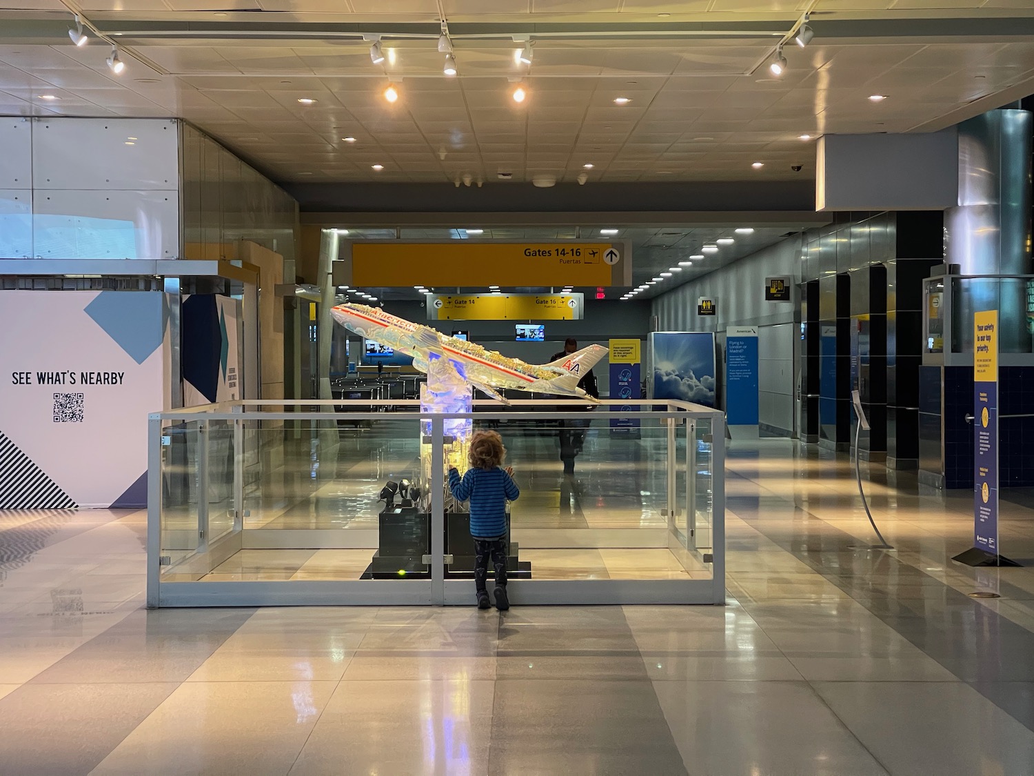 a child standing in front of a model of a plane