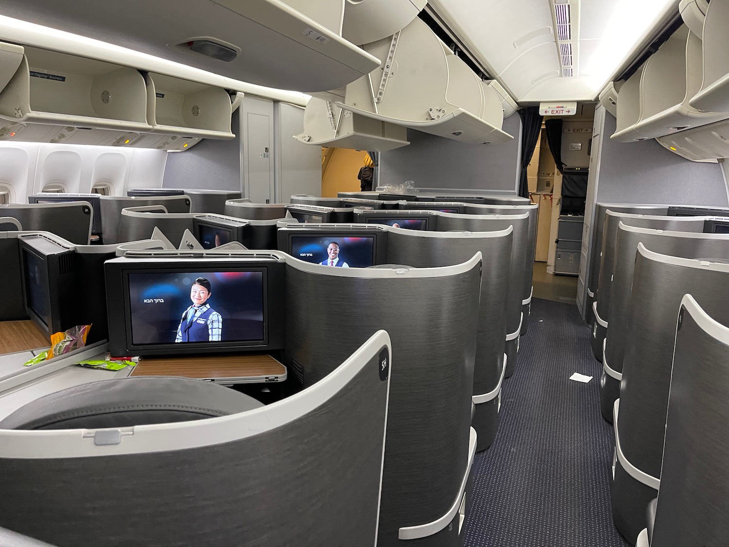 a room with rows of seats and televisions