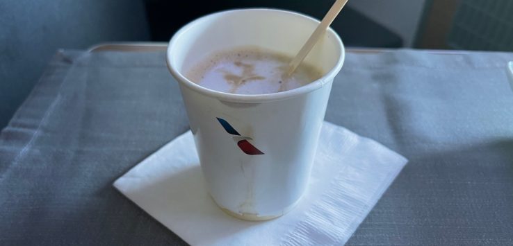 a cup of liquid with a wooden spoon