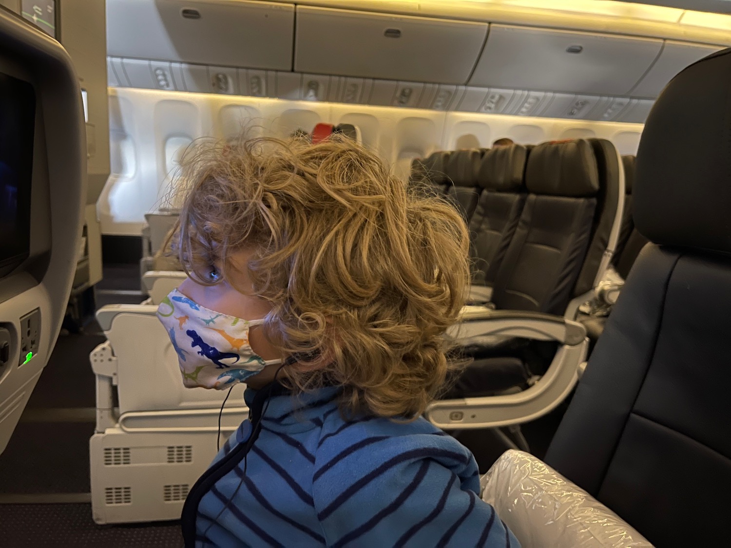 a child wearing a mask on an airplane