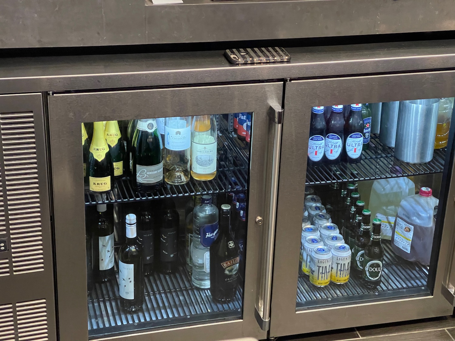 a refrigerator with bottles of beer and cans