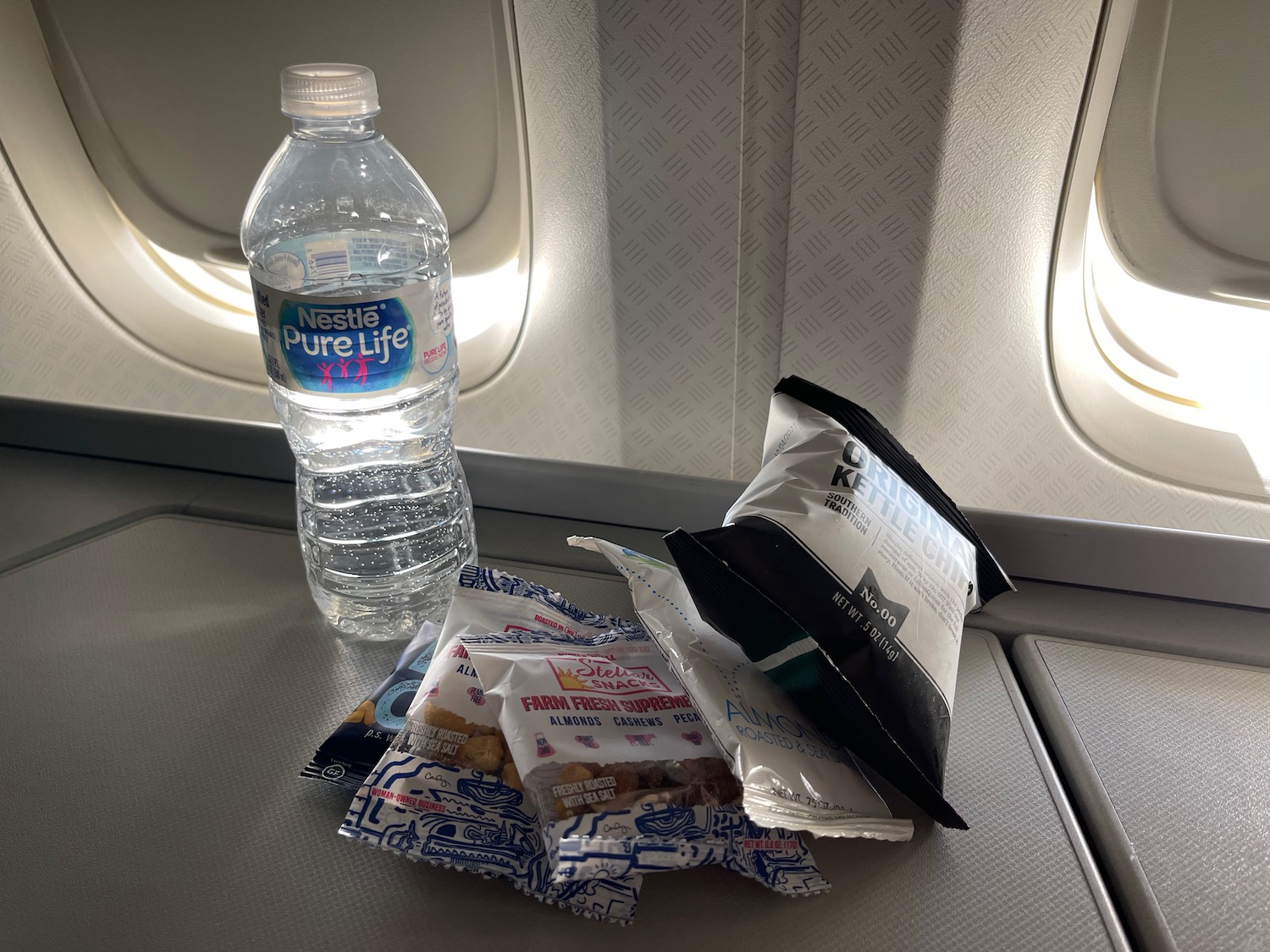 a bottle of water and snacks on a plane