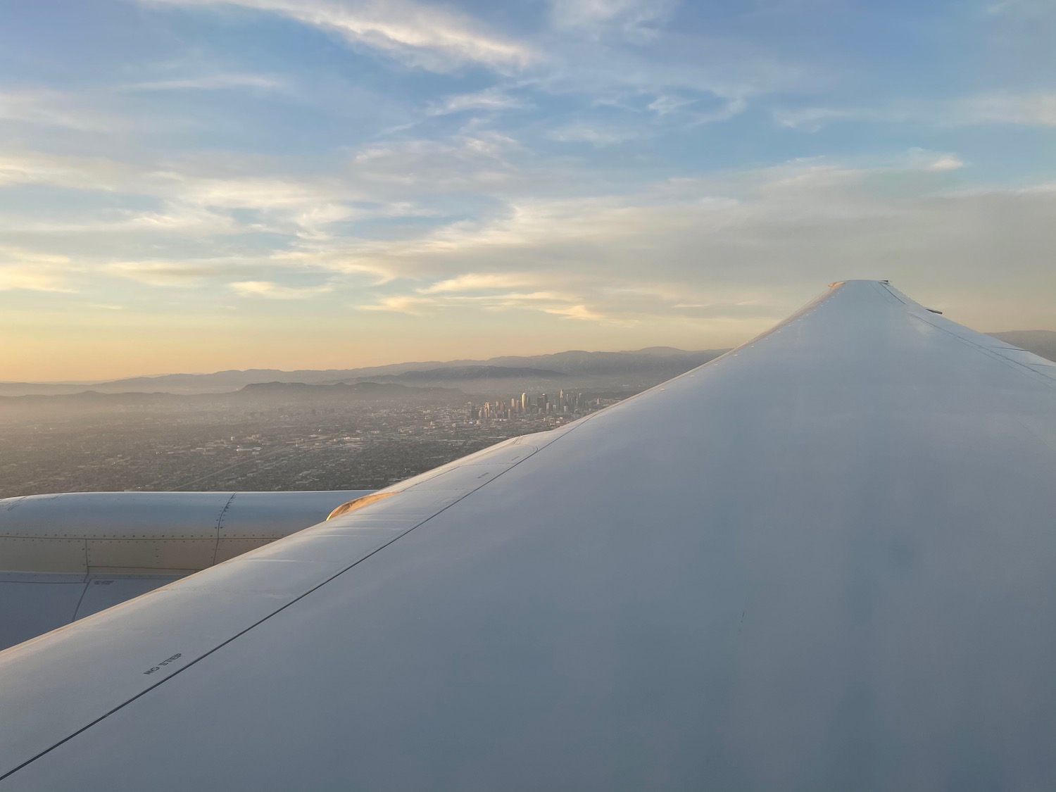 wing of an airplane with a city in the background