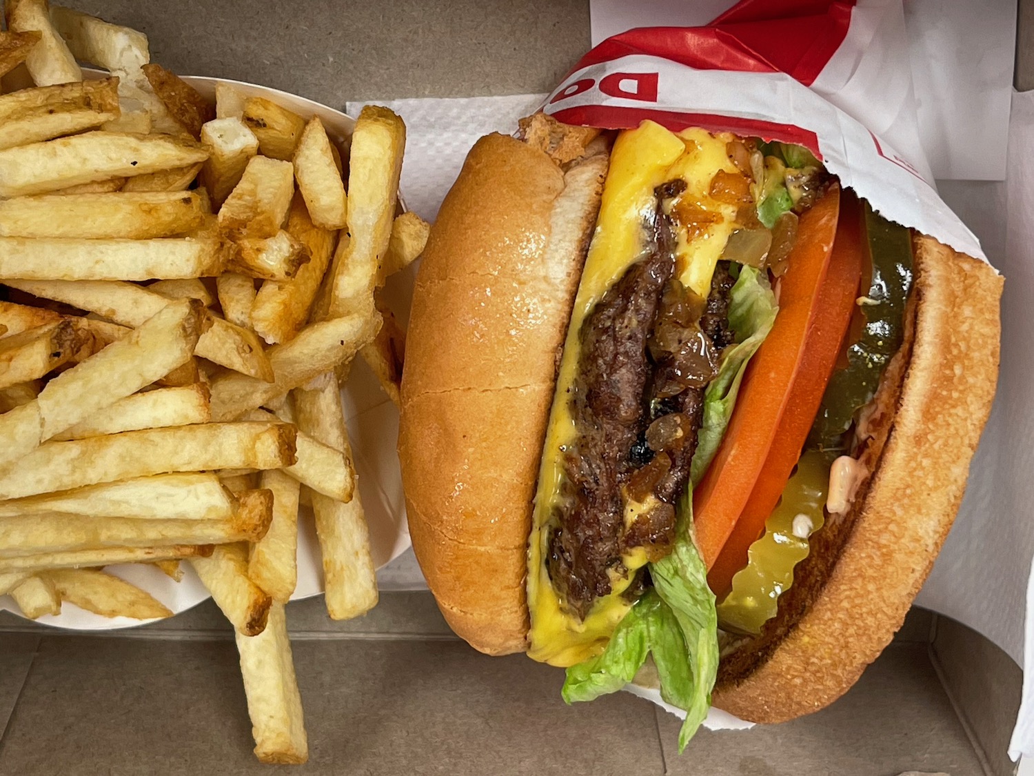 a burger and fries on a paper plate