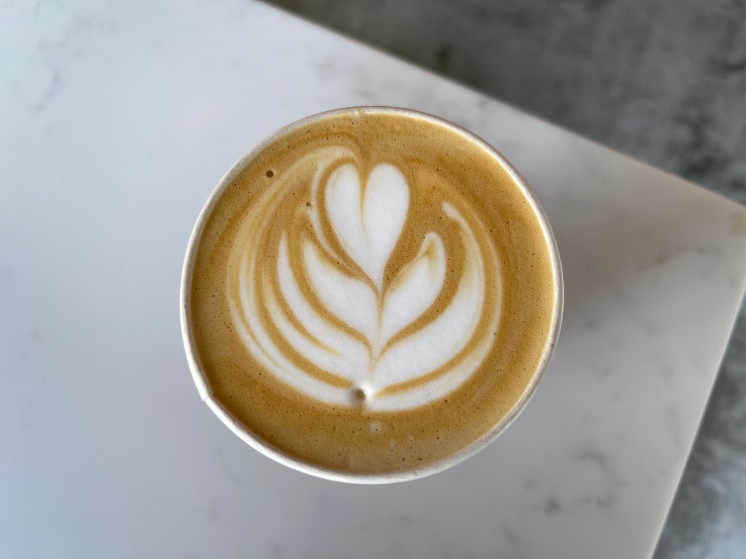 a cup of coffee with a design in the foam