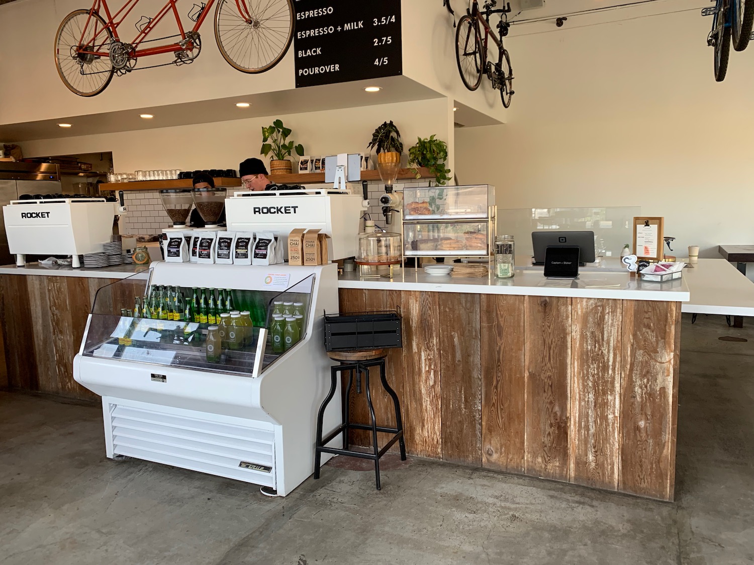 a coffee shop with a counter and a man behind it