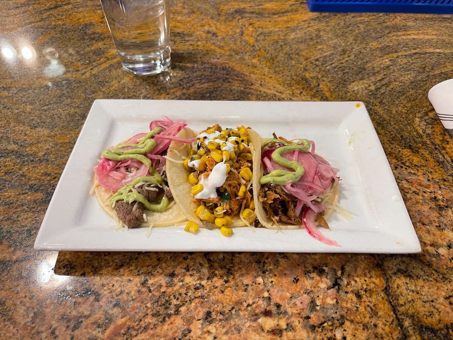 a plate of tacos with vegetables and sauce