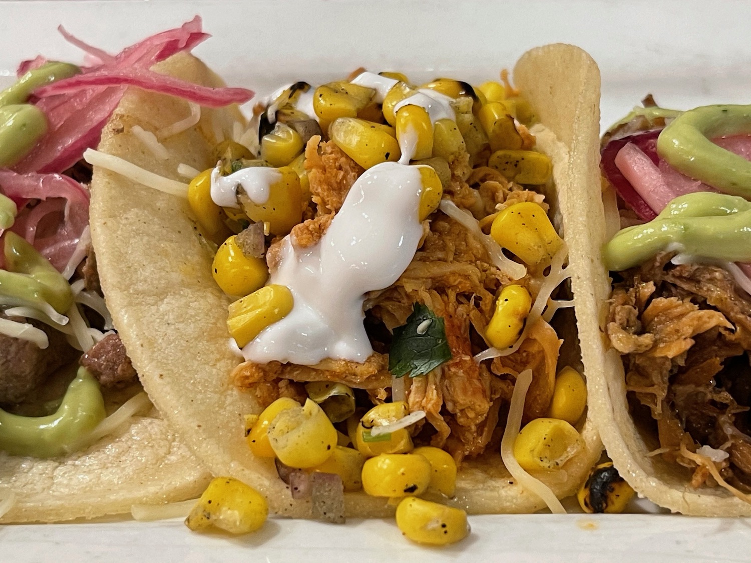 a group of tacos with meat and corn