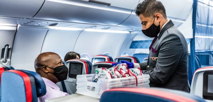 a man wearing a face mask and gloves in an airplane